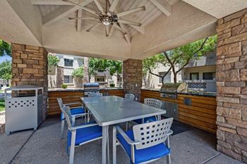 A patio with a table and chairs under a roof.